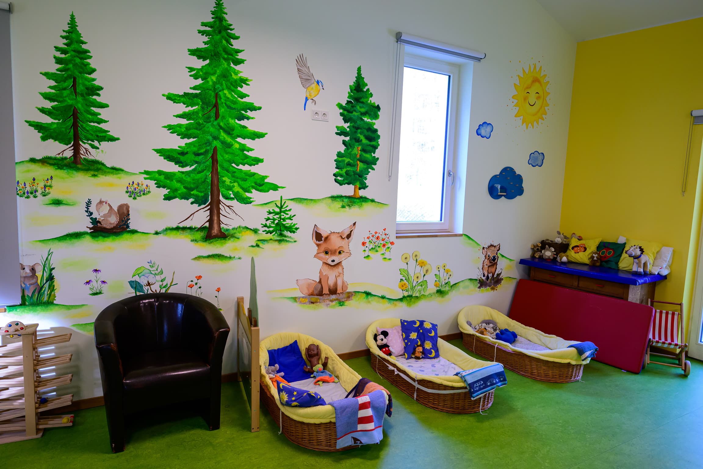 Ruhebereich mit Korbkörben und Waldbild an der Wand